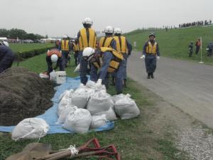 戸田市消防団員が土のうを活用し決壊防止法を実施している写真