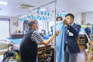 利用者と洗濯物を干す仕事をしている市長の写真