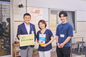 取材した施設前での代表と市長の記念写真