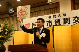 賀詞交歓会の市長挨拶で市制施行60周年ロゴマークとキャッチフレーズを紹介する様子