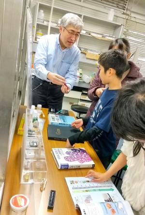 埼玉大学工学部無機化学研究室での見学会にて書籍の説明を受けるの様子