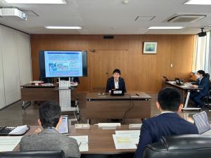 委員の前でプレゼンテーションする職員の写真
