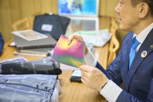 レンチキュラー印刷を施した軟質塩化ビニールに触れる市長