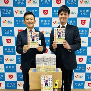 書籍の寄附贈呈式の様子（右：鈴木大輔さん、左：菅原市長）